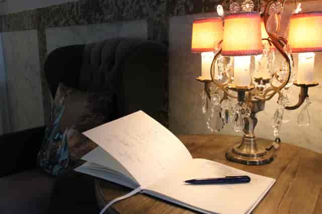 Upscale hotel library event foyer with classic guestbook station for corporate event registration.