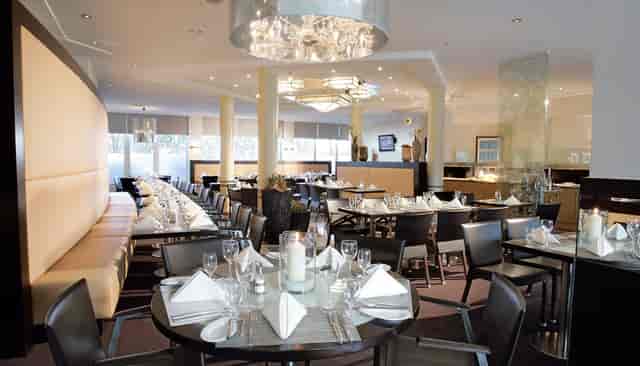 Banquet hall at Lindner Hotel Dusseldorf, featuring elegant table settings for corporate events.