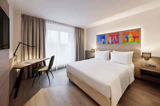 Modern hotel guest room at Lindner Dusseldorf Airport with ergonomic workspace for business events.