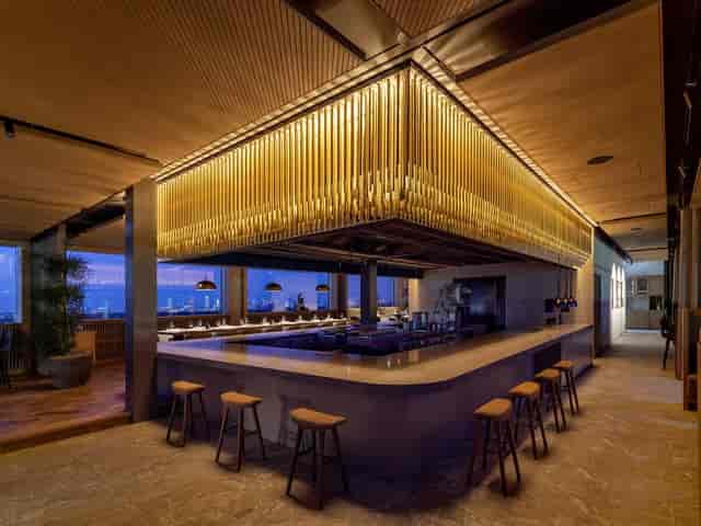 Upscale rooftop venue with illuminated bar for corporate cocktail reception and networking event.
