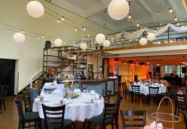 Industrial-chic wine bar in Schlossallee with string lighting for corporate and social events.