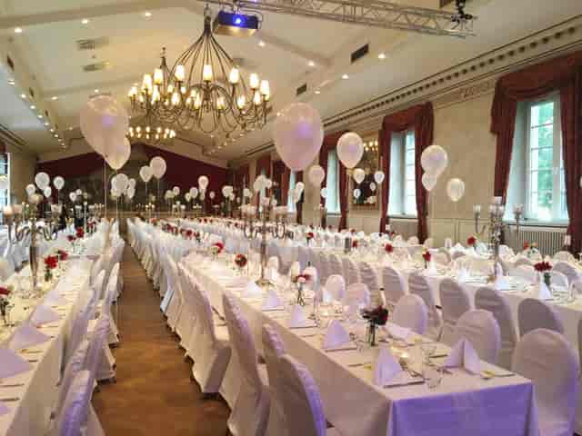Wolkenburg ballroom with banquet tables and candelabras for gala dinner or wedding event.