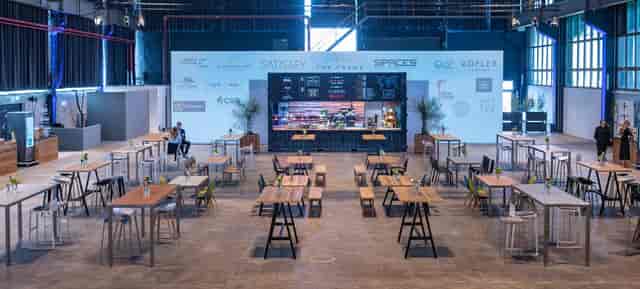 Industrial event space with shipping container catering station for networking and corporate events.