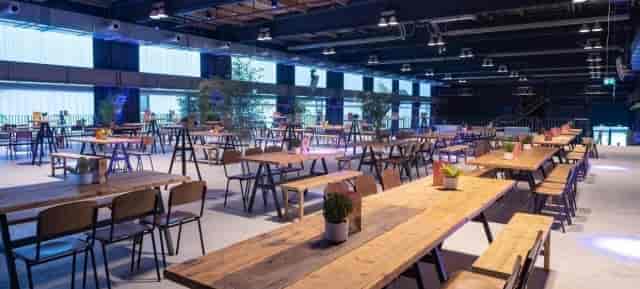 Industrial-chic LOFT EG venue with communal seating for corporate workshops and networking events.