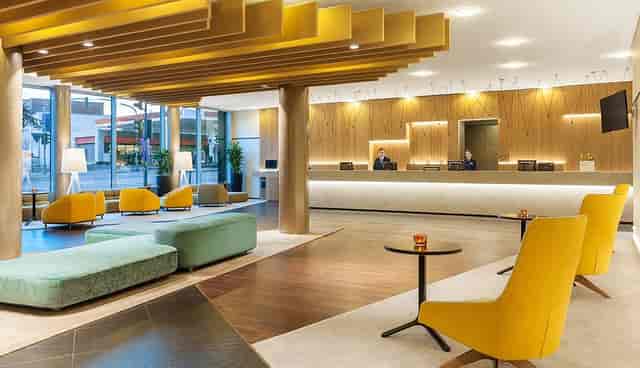 Modern hotel lobby with reception desk for event registration and group check-in networking.