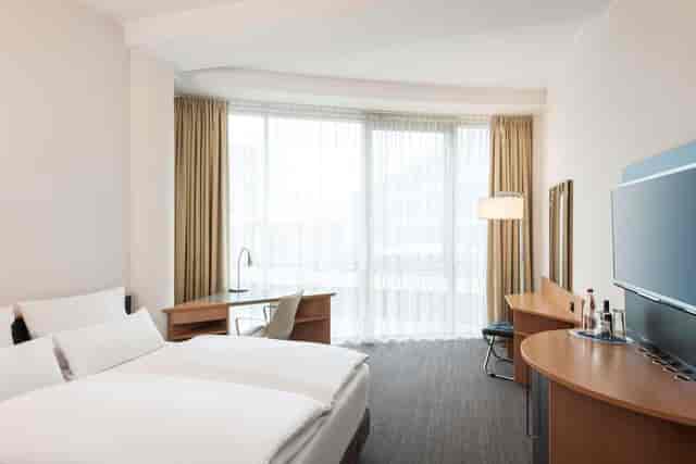 Saturn NH Düsseldorf City guest room with desk for business travel and corporate events.