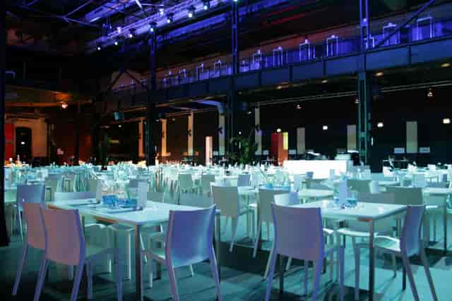Palladium Köln industrial banquet hall with blue lighting for corporate events and conferences.