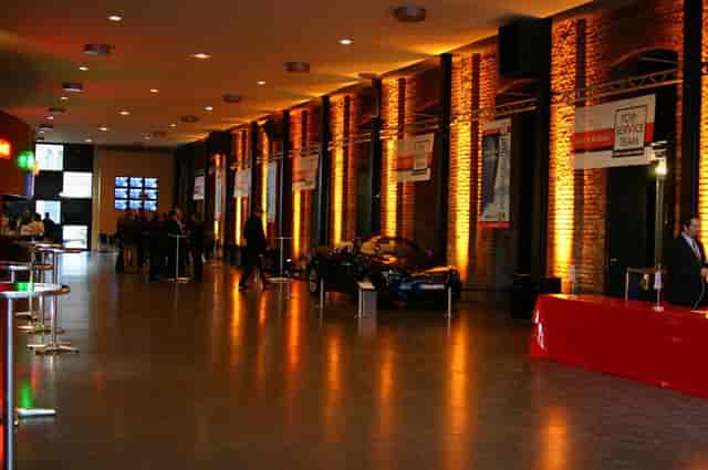 Palladium Köln industrial corporate reception venue with car display and atmospheric uplighting.