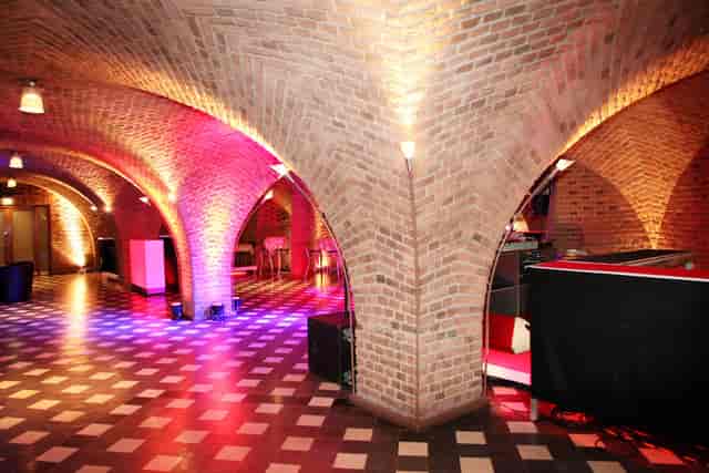 Weinkeller vaulted event space with dramatic architectural lighting for receptions and brand events.