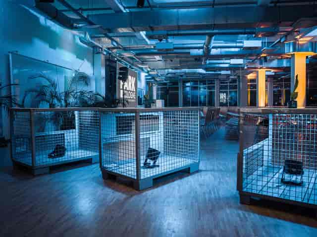 Industrial-chic event space at Bahnhofstraße Cologne with caged displays for gallery networking.