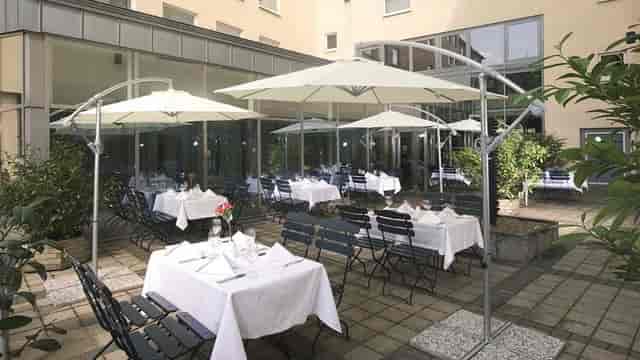 Outdoor terrace at Eigelstein, Cologne with white tables for networking receptions and lunch events.