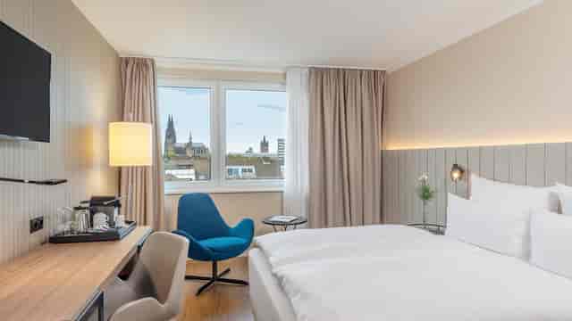 Modern hotel room in Ehrenfeld, NH Koeln Altstadt with workspace for business travel events.