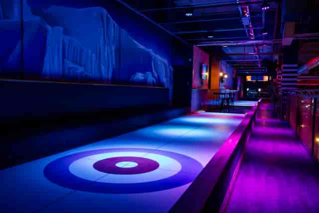 Trendy Nottingham event space with modern curling lane and vibrant purple lighting.
