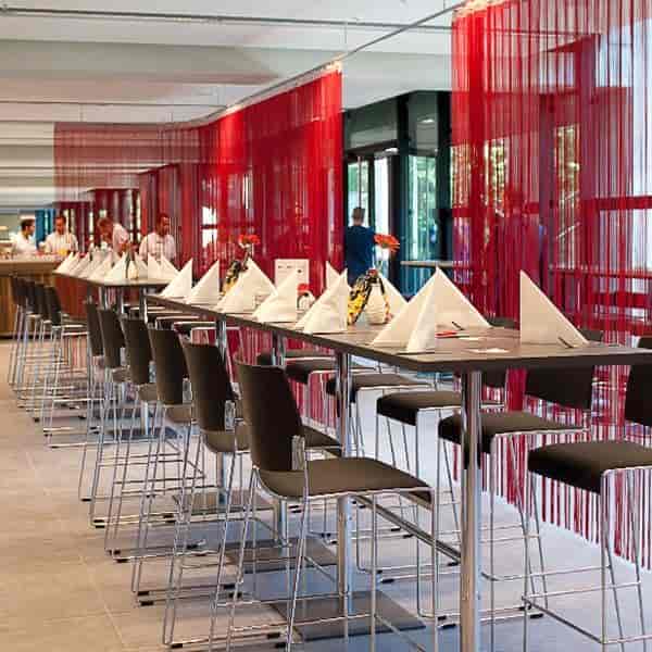 Dombar at RheinEnergieSTADION: Red-draped communal networking space for corporate events.