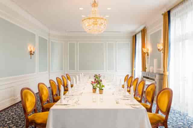 Elegant boardroom at Excelsior Hotel Ernst with gold velvet chairs, ideal for executive meetings.