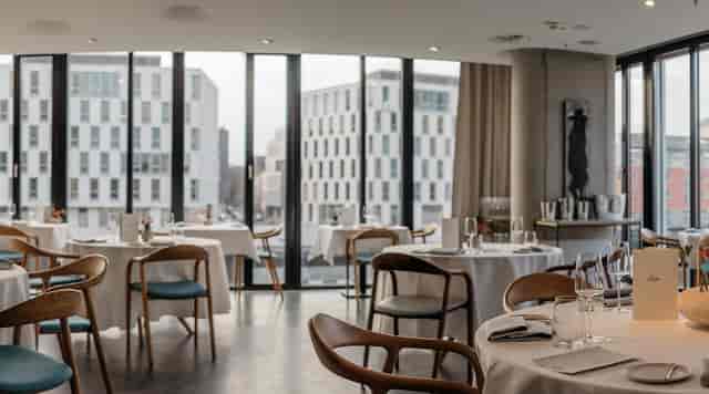 Modern Ox & Klee dining space with round tables for corporate luncheons and board meetings.