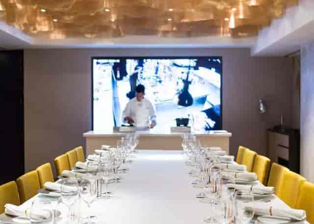 Private dining at Caelis with integrated AV wall for corporate events and chef demonstrations.