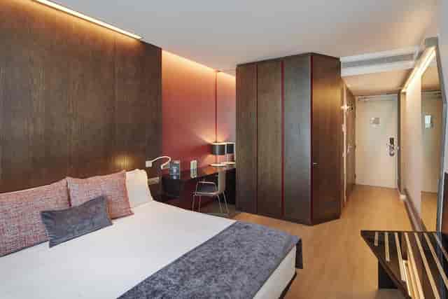 Modern Sercotel Rosellón guest room with workspace, ideal for business travel and conference lodging.