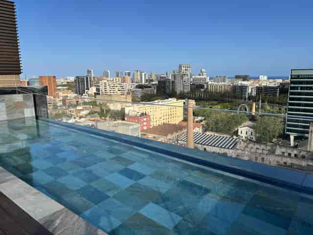 Rooftop meeting room with infinity pool and city skyline for networking mixers and VIP receptions.