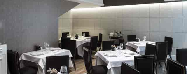 Upscale square dining tables for business dinners in a professional Catalonia restaurant setting.