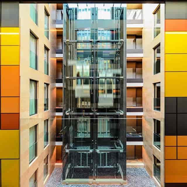 Modern hotel atrium with glass elevator bank for event venue and conference planning.