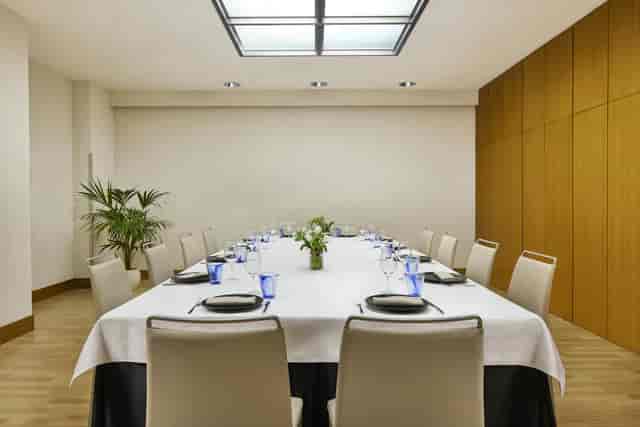 Formal boardroom setup with floral decor for executive lunch or business meeting at NH Barcelona.