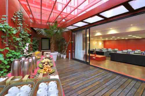 Red meeting room with outdoor terrace for corporate events and professional networking.