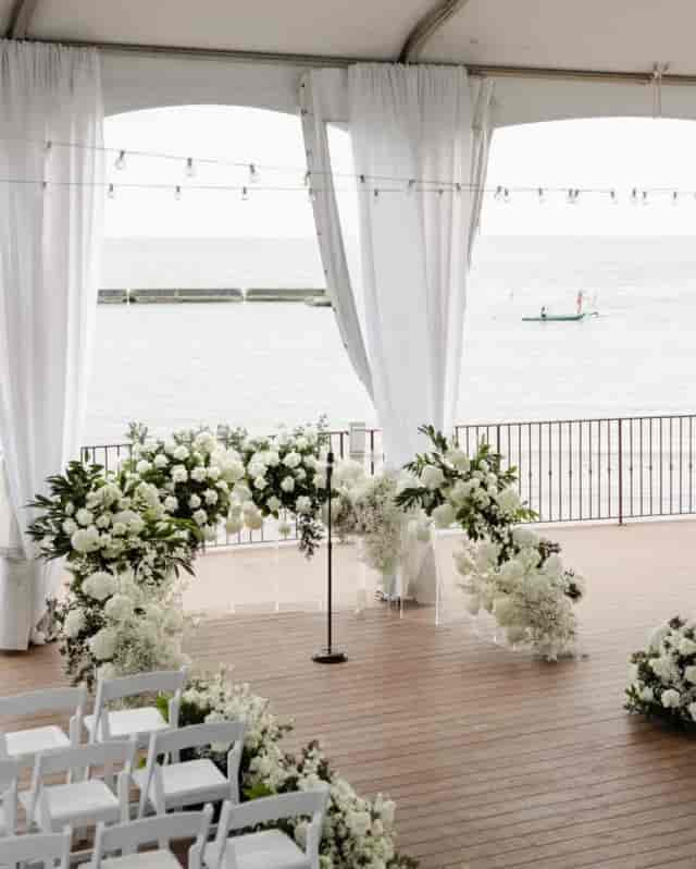 Minimalist floral arch at Palais Royale waterfront wedding ceremony.