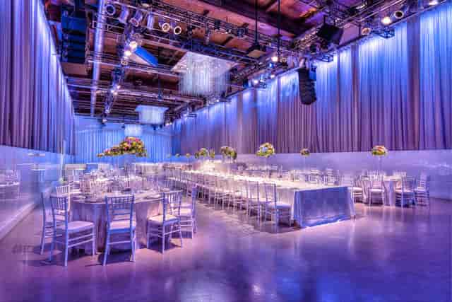 Liberty Grand Courtyard gala dinner with blue uplighting and chic banquet seating.