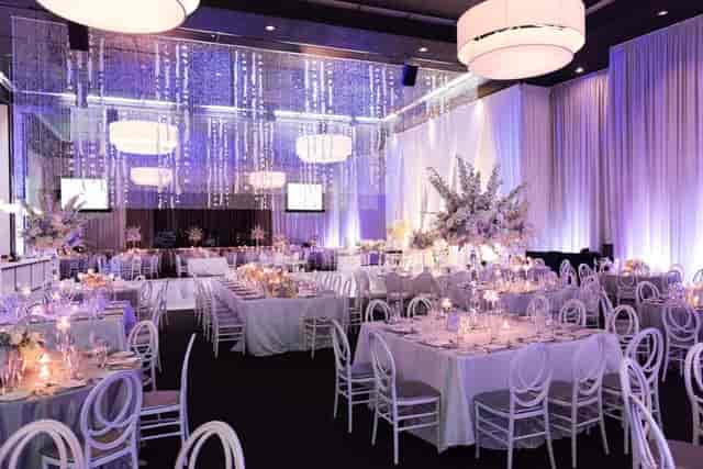 Luxury ballroom with elegant chandeliers for high-end wedding reception or gala event.