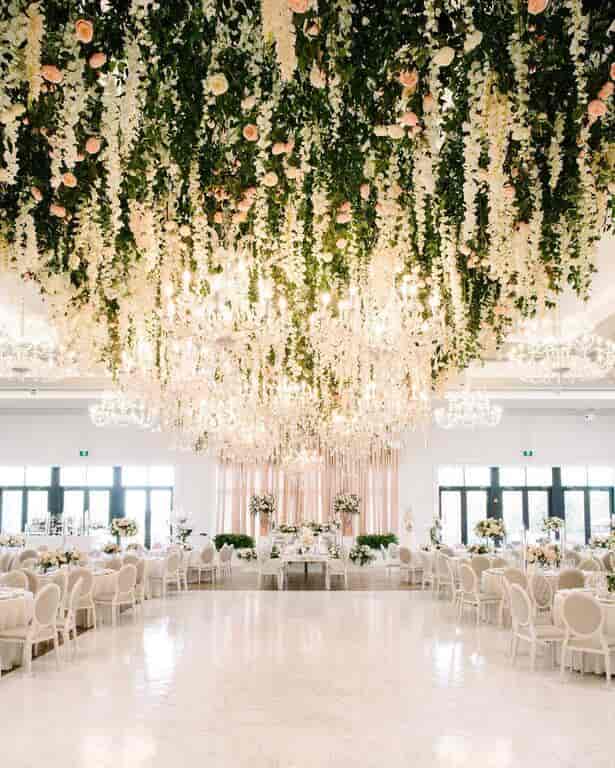 Floral ceiling installation with crystal chandeliers at The Arlington Estate luxury wedding venue.