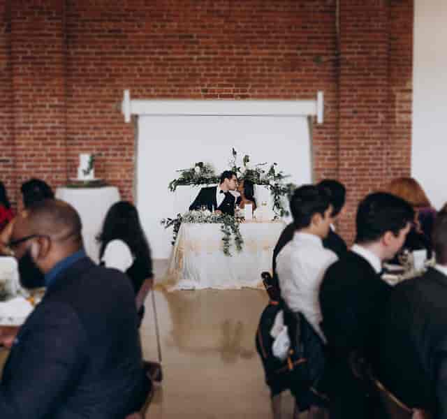 Sweetheart table at industrial-chic TCE on Sterling wedding venue with exposed brick and florals.