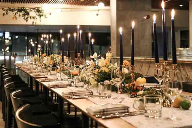 Long-table dinner setup at Oretta Midtown Mezzanine with taper candles for gala corporate events.