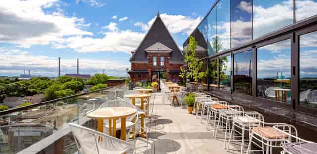 Rooftop terrace bar with brick and glass architecture for cocktail receptions and networking events.