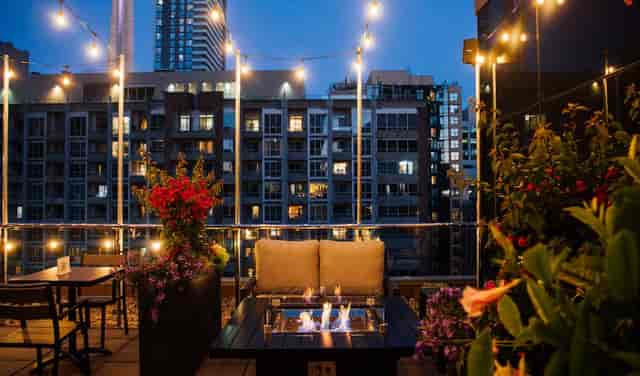 Rooftop cafe networking mixer with fire pit seating and urban skyline views.