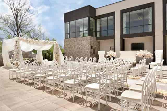 Modern outdoor ceremony courtyard at IKON Event Space with white Chiavari chairs for weddings.