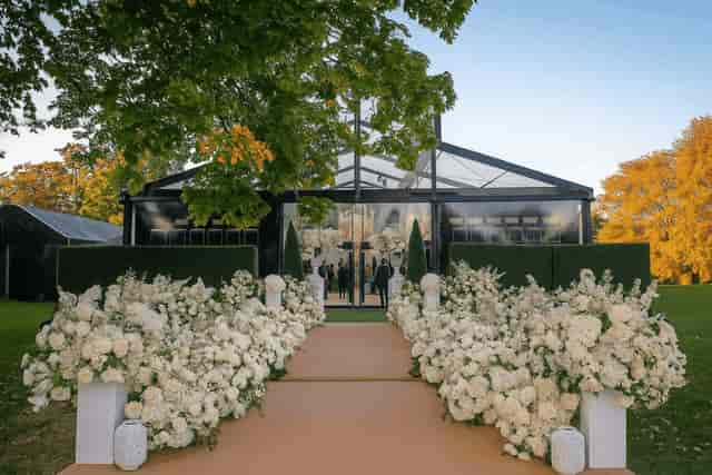 Luxury outdoor marquee banquet hall with floral installations for high-end wedding events.