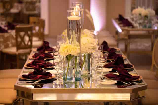 Elegant gala tablescape with mirrored table and floating candles for luxury wedding reception.