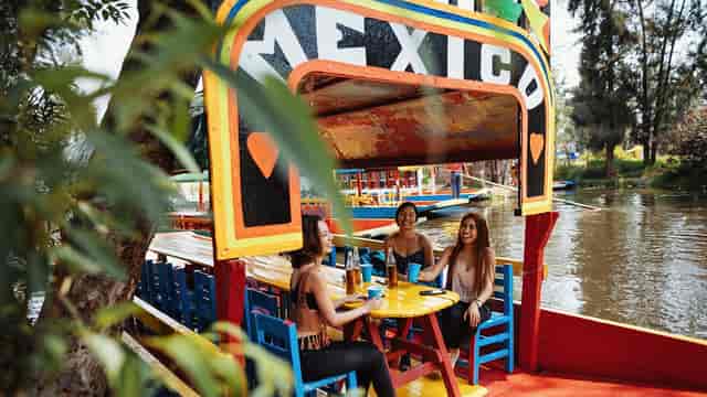 Colorful branded trajinera boat for corporate group networking event and destination team building.