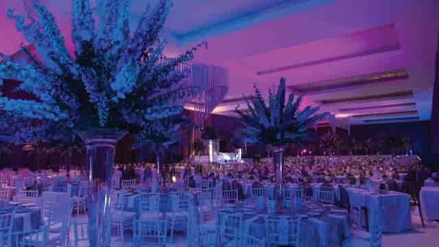 Gran Salón Aqua ballroom with purple lighting and floral decor for luxury corporate events.
