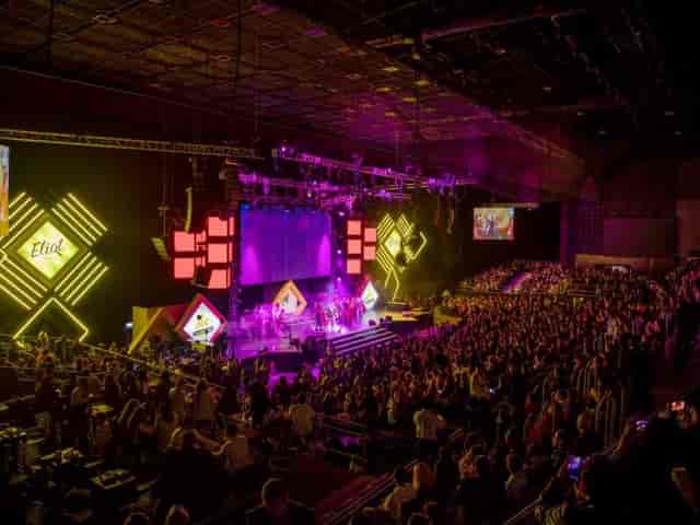 Branded stage design with dynamic LED lighting at a Frontón México corporate event or conference.