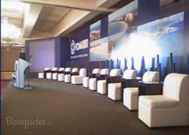 Corporate panel stage in Palacio La Rochelle drawing room with branded backdrop and lounge seating.
