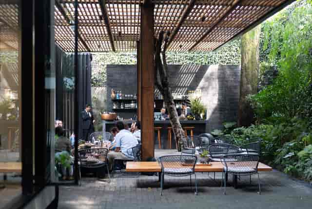 Pujol restaurant with lush semi-outdoor design for corporate networking events.
