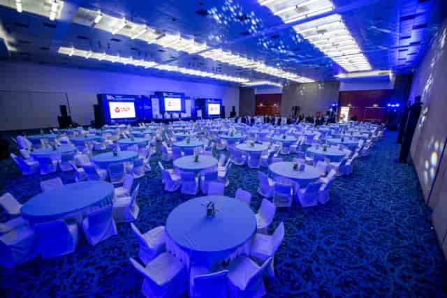 Centro Banamex ballroom, gala banquet setup with blue LED lighting and triple-screen AV staging.