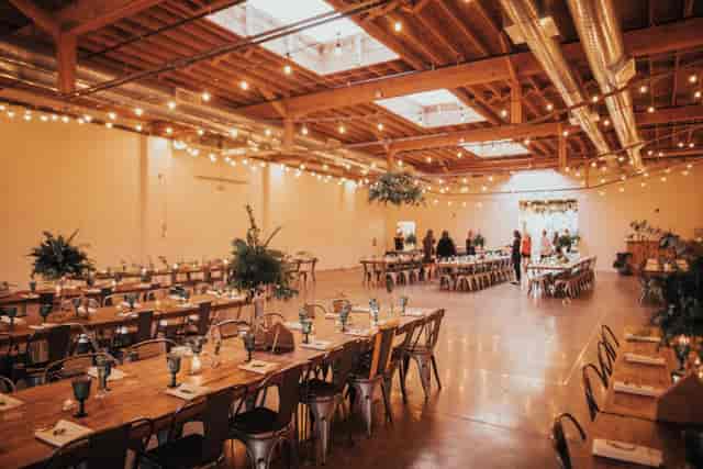 Industrial-chic event venue with truss ceilings, perfect for weddings and corporate gatherings.