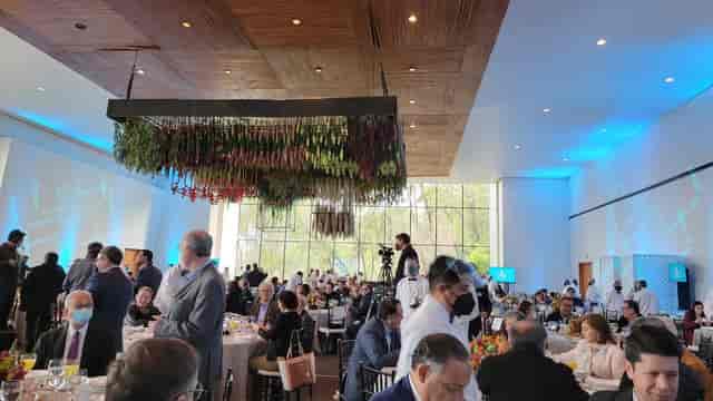 Corporate luncheon at Banquetes Mayita featuring suspended floral installations for event decor.