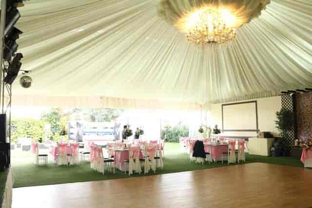 Salón Jardín marquee venue with draped ceiling and chandeliers for wedding or social event.
