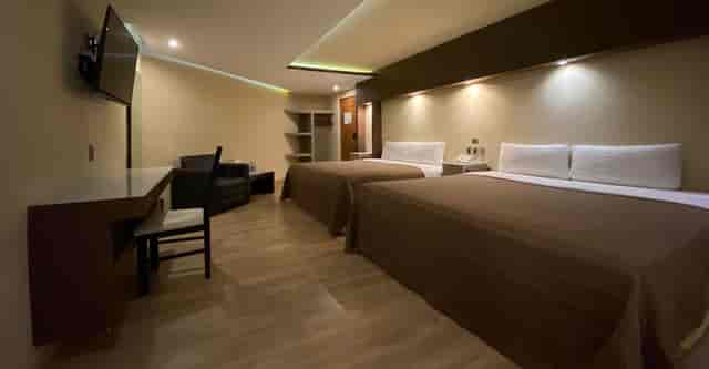 Double-occupancy hotel room with workspace for conference accommodation.