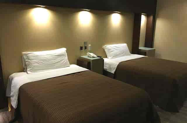 Double-occupancy hotel room for budget conference delegates and event accommodation.