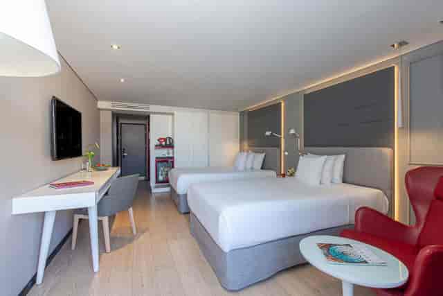 Modern dual-occupancy hotel room with workspace, ideal for business conferences and events.